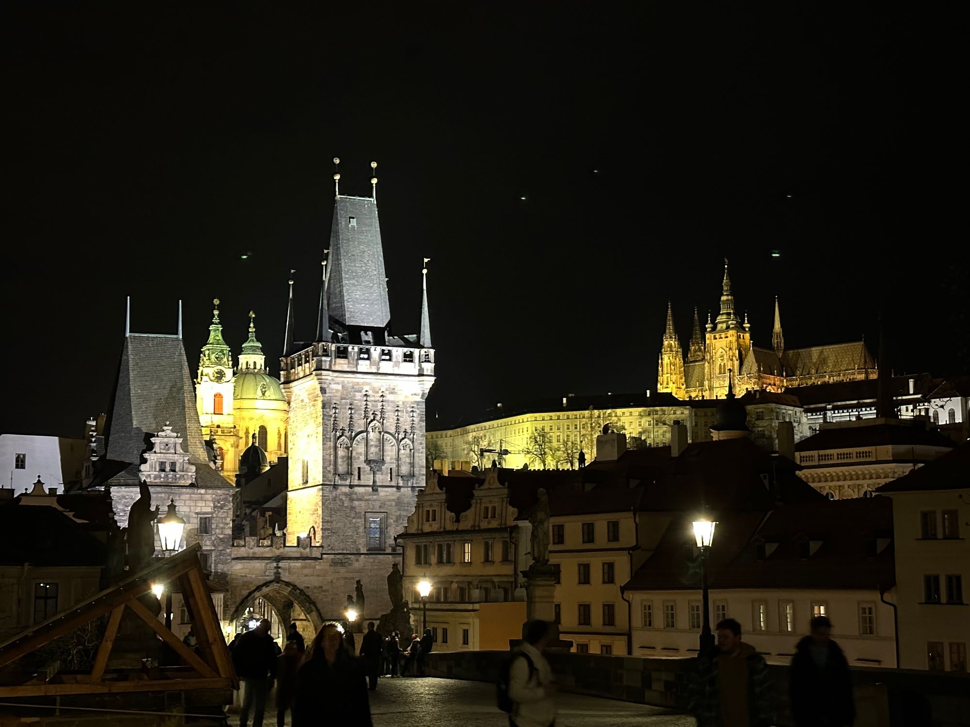 night image of Prague Castle, the guard tower at the south end of the Charles Bridge, and the lower bell tower